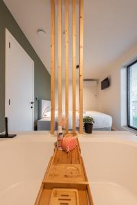 mesa de madera en un dormitorio con cama en NIEUW De Grenspaal NOORD 6P - 3SLPK 5 min Maastricht - SAUNA - LAADPAAL, en Riemst