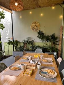 a wooden table with many plates of food on it at Casa de Ali in Pereira +34 photos