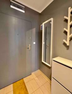 een badkamer met een wastafel, een spiegel en een deur bij ApartBroniewskiego in Toruń