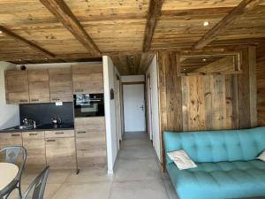 a living room with a blue couch and a kitchen at Appartement 2 pièces pour 4 pers avec balcon à l'Alpe d'Huez - FR-1-405-227 in LʼHuez +3 photos
