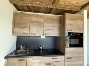 a kitchen with wooden cabinets and a sink at Appartement 2 pièces pour 4 pers avec balcon à l'Alpe d'Huez - FR-1-405-227 in LʼHuez