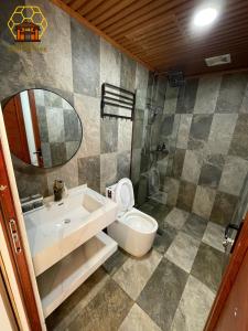 y baño con lavabo, aseo y espejo. en Mèo Vạc Beehive House, en Mèo Vạc