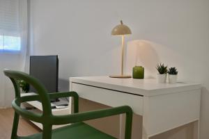 einem grünen Stuhl neben einem Schreibtisch mit einem Computer in der Unterkunft For You Rentals Coqueto y amplio Studio en el Barrio Quintana ALE141º in Madrid