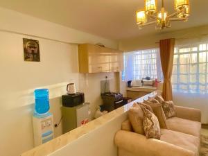 ein Wohnzimmer mit einem Sofa und einer Küche in der Unterkunft Serenity World in Nairobi