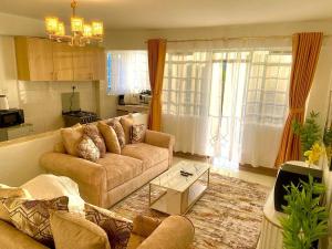 ein Wohnzimmer mit einem Sofa und einem Tisch in der Unterkunft Serenity World in Nairobi