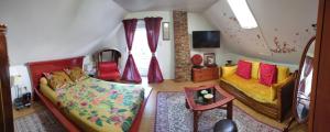 ein Wohnzimmer mit 2 Betten und einem TV in der Unterkunft Maison d'hôte privatisée avec piscine et jacuzzis 15 pers max in La Couture-Boussey