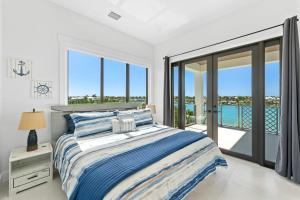 马拉松Luxury Seaside Escape ~ Heated Pool w Jacuzzi ~ Elevator ~ Dock ~ Scenic Views的一间带床和阳台的白色卧室 更多37张照片