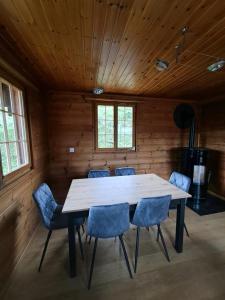 Troistorrents的住宿－Au Chalet，一间带桌子和蓝色椅子的用餐室