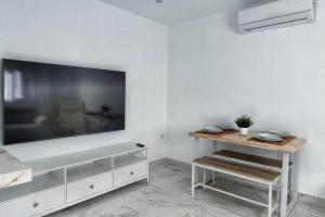 een woonkamer met een grote flatscreen-tv aan de muur bij Apartamento CENTRO, La Palmera. in Huelva