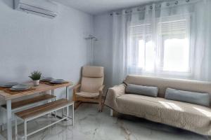 uma sala de estar com um sofá e uma mesa em Apartamento CENTRO, La Palmera. em Huelva