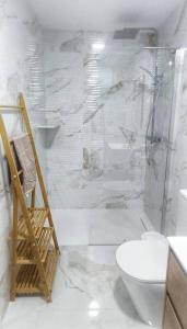 uma casa de banho branca com um chuveiro e um WC. em Apartamento CENTRO, La Palmera. em Huelva