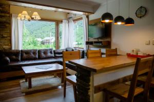 sala de estar con sofá y mesa con sillas en Apartamentos Catedral Inn en San Carlos de Bariloche