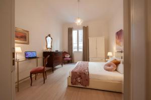 1 dormitorio con cama, escritorio y silla en Bargello - Flo Apartments, en Florencia