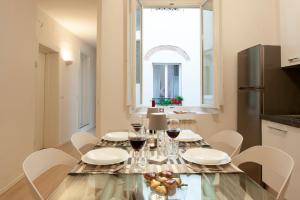 ein Esszimmer mit einem Tisch und Gläsern Wein in der Unterkunft Bargello - Flo Apartments in Florenz