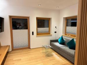 a living room with a couch and two windows at Appartement Erler in Sankt Johann in Tirol