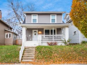 a gray house with a white door and stairs at Staying Comfortable in Central Columbus, Pet Friendly, 30 Day Min Stay in Columbus