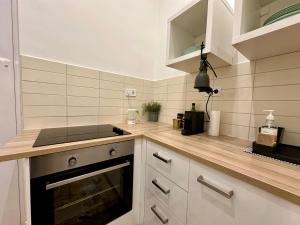 cocina con armarios blancos y encimera en Cozy studio flat in the heart of Budapest, en Budapest