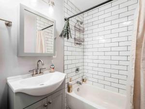 a white bathroom with a sink and a bath tub at Staying Comfortable in Central Columbus, Pet Friendly, 30 Day Min Stay in Columbus