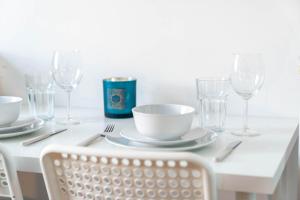 a white table with plates and wine glasses on it at Sky Rooms One Bedroom Modern Studio Apartment 3 in Birmingham