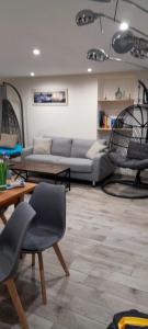 sala de estar con sofá, sillas y mesa en Maison de 3 chambres avec jardin clos et wifi a Quettehou, en Quettehou