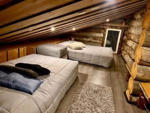 a bedroom with two beds in a log cabin at Villa Kelo in Rovaniemi