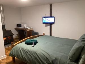 a bedroom with a bed with a tv on the wall at Barn 6 in Vigo Village
