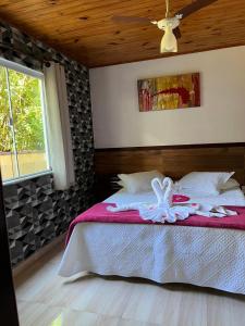 sypialnia z łóżkiem z ręcznikami w obiekcie Pousada Sabor da Serra w mieście Visconde De Maua