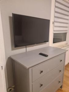 a tv on top of a dresser with a remote control at Schöne 2 Zimmer Apartment in Uerdingen Nähe Düsseldorf in Krefeld