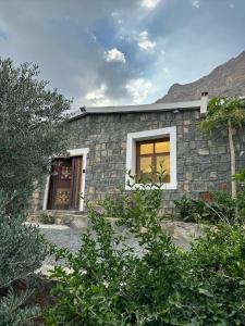 una casa de piedra con una ventana en el lateral. en Jabal Shams Villa, en Sa‘ab Banī Khamīs