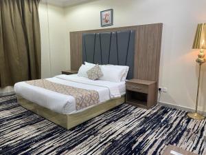 um quarto de hotel com uma cama e um candeeiro em سكون سويت للشقق الفندقية em Hail