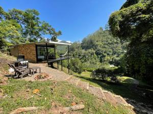 a cabin with a table and a bench on a hill at La ceiba cabaña in La Vega
