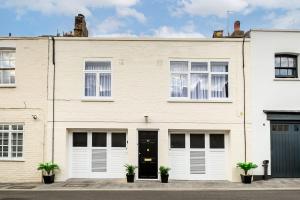 uma grande casa de tijolos brancos com uma porta preta em London's Charm Modern 2BR Marylebone's Best Spot em Londres
