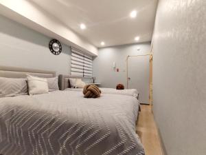 a bedroom with a large bed with a stuffed animal on it at S21新宿最中心 東新宿站5分-Shinjuku center 5 mins to Station, Max 3P 直达新宿 涉谷 表参道 池袋 上野 代代木 银座 原宿 in Tokyo