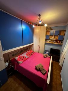 a small bedroom with a pink bed and a blue wall at A COLLODI IO & MAMMA in Collodi