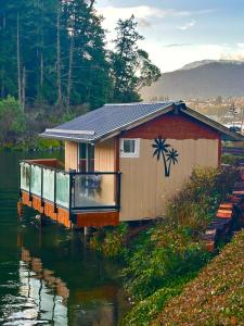 a house in the middle of a body of water at Trails End Beach House suite with hot tub and beach bedroom cabin! in Ladysmith