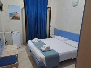 a hotel room with a bed and a blue curtain at G&G - Bed & Breakfast in Vieste