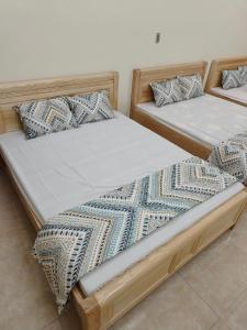 two beds sitting next to each other in a room at Tom's house motorbikes tour and homestay in Làng Me