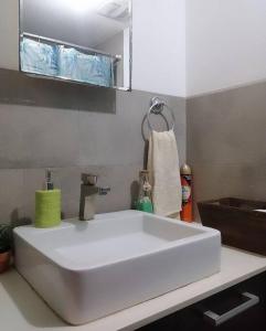 La salle de bains est pourvue d'un lavabo blanc et d'un miroir. dans l'établissement Apartamento zona 4 Guatemala y Parqueo, à Guatemala
