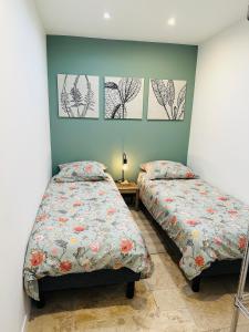 two beds sitting next to each other in a bedroom at Magnifique appartement au centre-ville de Nice in Nice