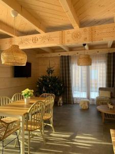 a dining room with a table and chairs at Uroczy drewniany domek - Domki pod Brzegiem in Zakopane