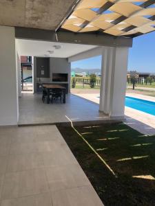 an open patio with a table and a pool at AIRES DEL LAGO, Los Molinos 2 in Potrero de Garay