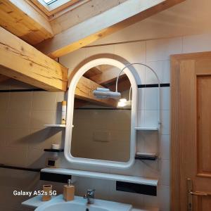 a bathroom with a mirror and a sink at Appartamenti DOLOMITI in Fai della Paganella +68 photos
