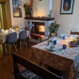 uma sala de jantar com duas mesas e uma lareira em A COLLODI IO & MAMMA em Collodi
