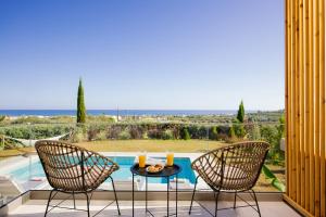 a patio with a table and two chairs and a pool at Olive Garden Residence in Platanes