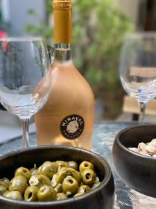 - une bouteille de vin et un bol d'olives à côté des verres dans l'établissement Magnifique appartement au centre-ville de Nice, à Nice