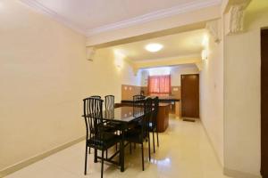 a dining room with a table and chairs at Sky High Cottages in Ooty