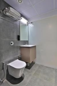 uma casa de banho com um WC branco e um lavatório. em Hotel Shivashish em Ahmedabad