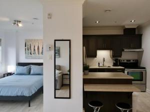 een keuken en een slaapkamer met een bed in een kamer bij Modern Loft Chute-Montmorency in Boischâtel
