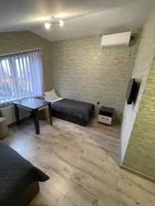 Una habitación con una cama, una mesa y un televisor. en Ні пуху, ні пера!, en Reshetylivka