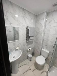 a white bathroom with a toilet and a sink at Ні пуху, ні пера! in Reshetylivka +18 photos